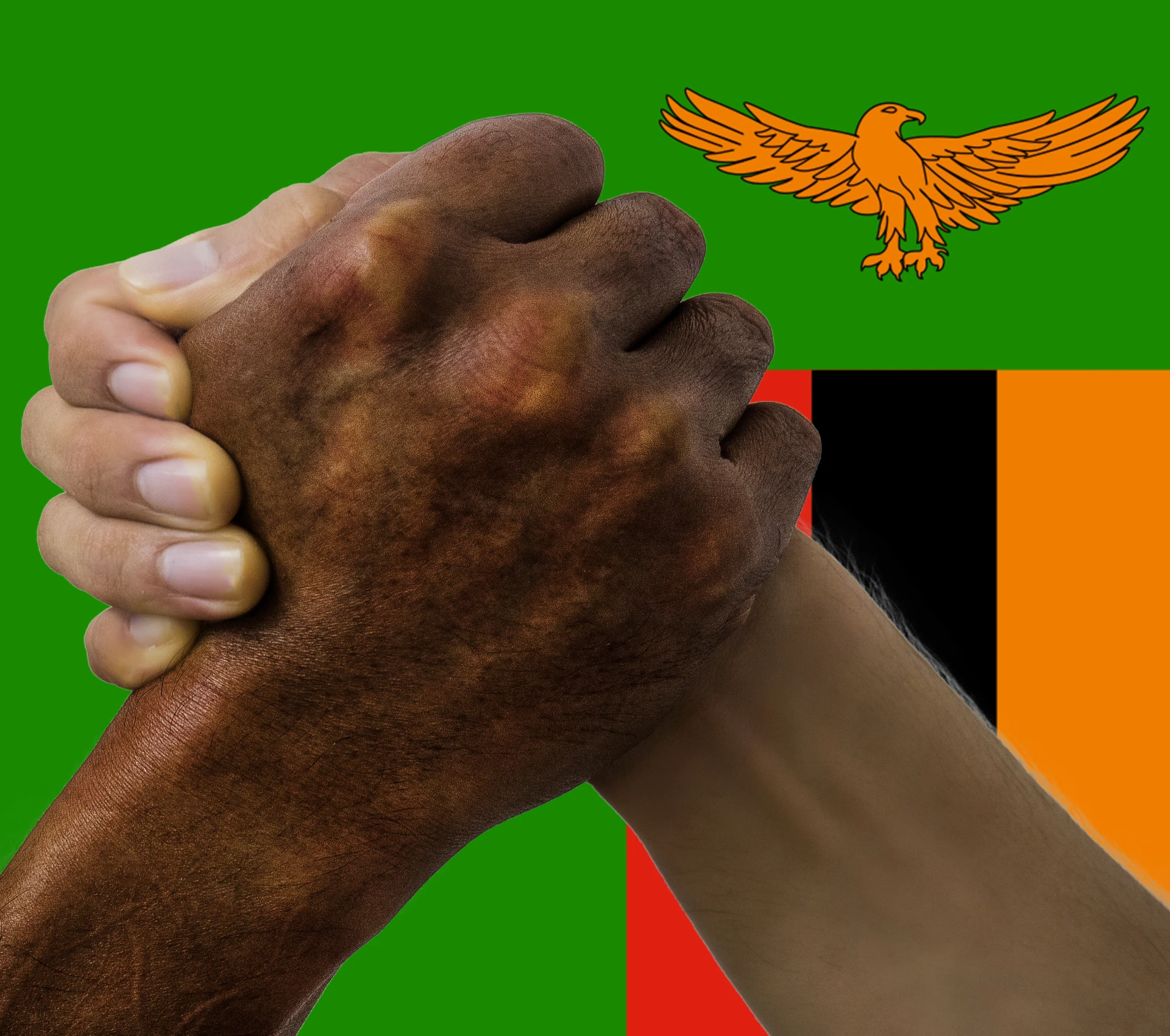 Two hands clasped over Zambian flag background.