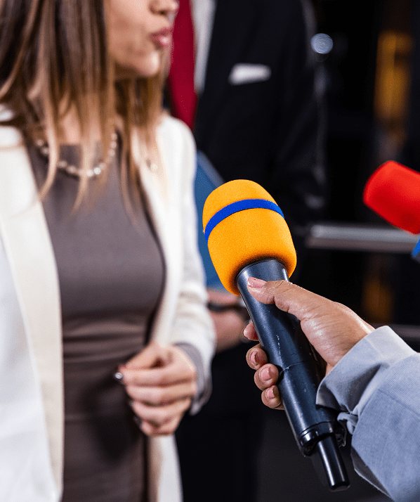 Person being interviewed by multiple microphones.